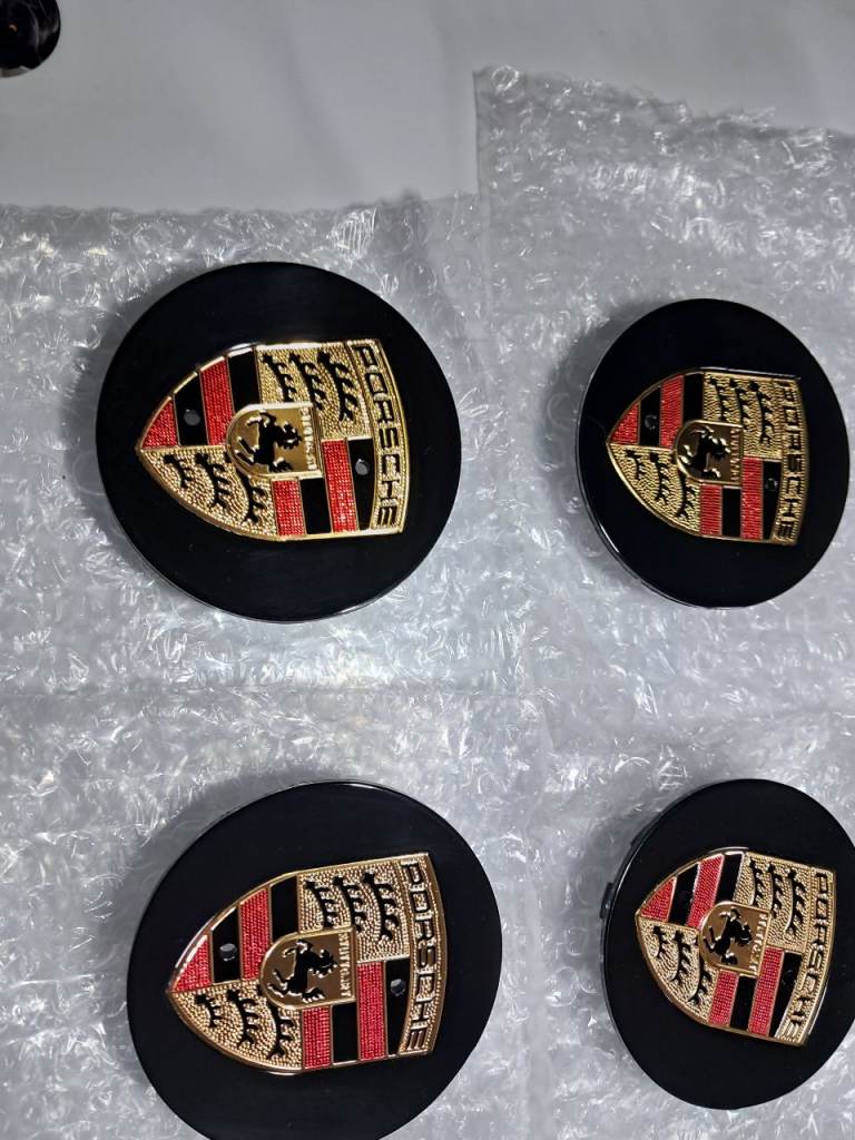 porsche wheel centre caps in silver or gloss black .