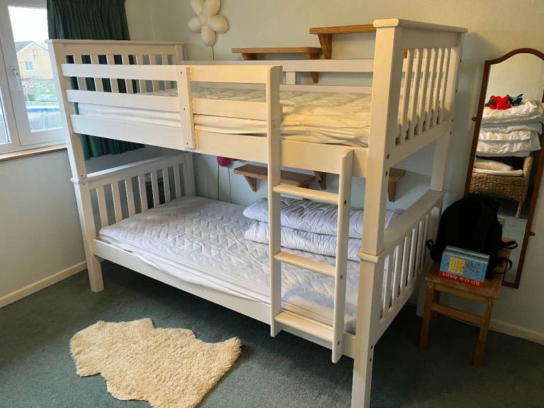 Sturdy white bunk beds with mattresses