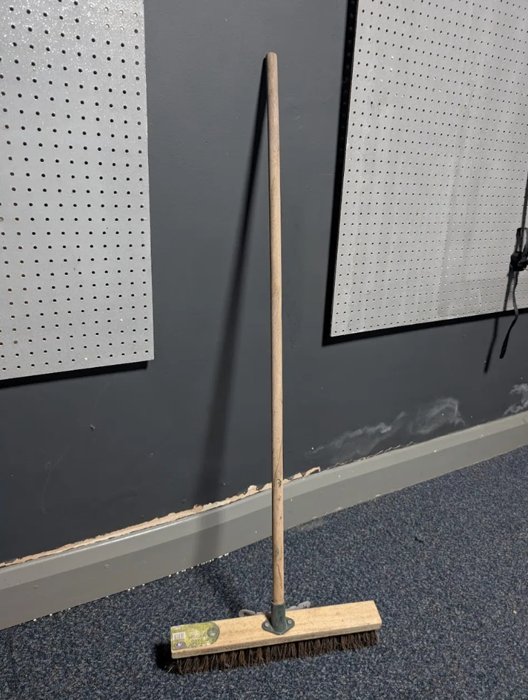 Mason & Jones yard broom with stiff natural bristles and wooden handle.