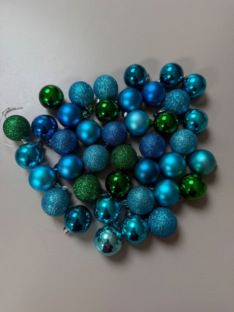 40 mini Christmas baubles in blues and greens.