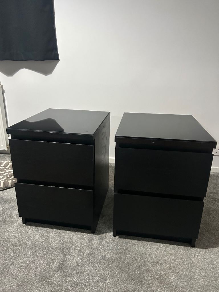 Two black Ikea malm beside tables with glass 