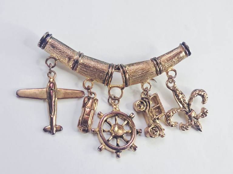 Vintage gold tone travel charm bracelet with various iconic 3D charms.