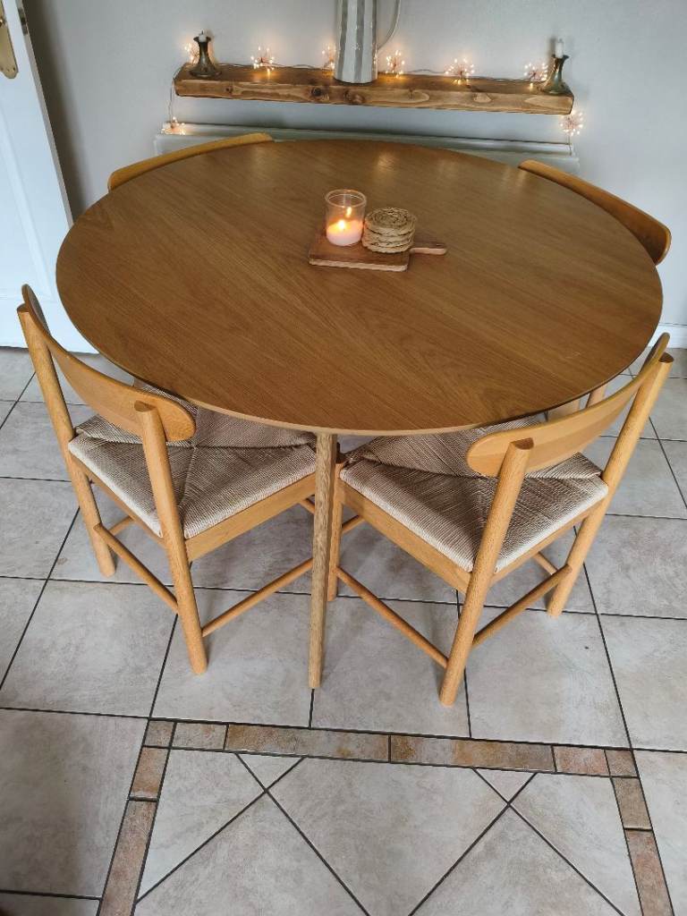 Oak coloured solid round dining table with four beautiful chairs