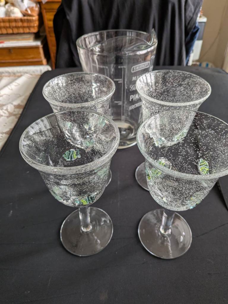 Four hand blown Art glass goblets and a pitcher.