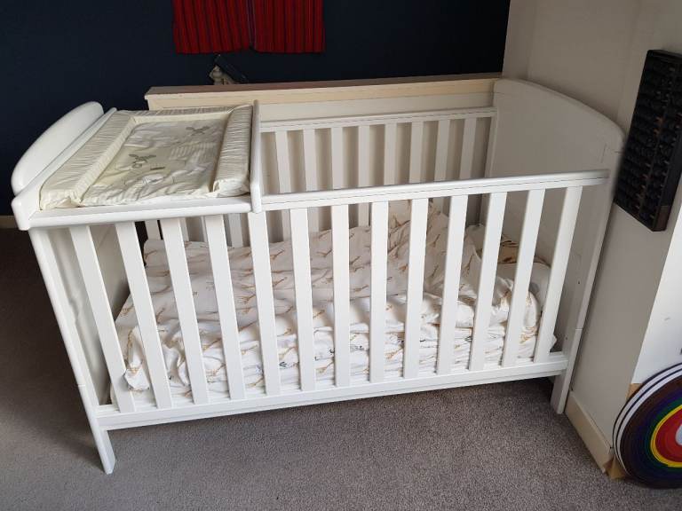 Baby cot with bedding, high chair, car seat, and stair gate