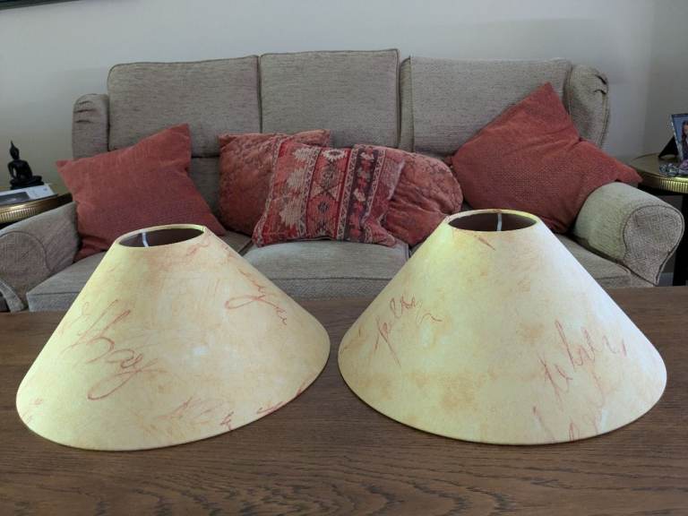 A pair of mustard colour lampshades with burnt orange flecking