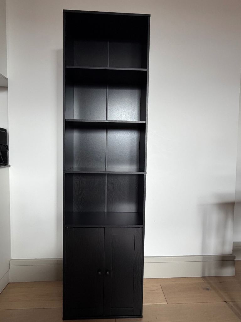 Tall Black Bookcase with Cupboard – Good Condition. Measuring cm 25W × 50L × 180H.
