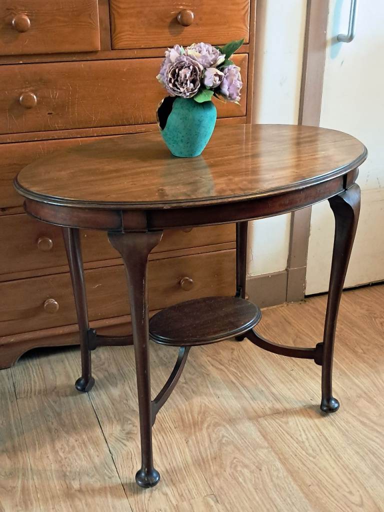 brown antique Edwardian mahogany oval side table with a lower tier, likely dating from around 1905.