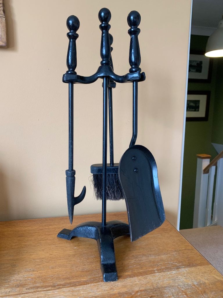 A classic black cast iron fireplace companion set