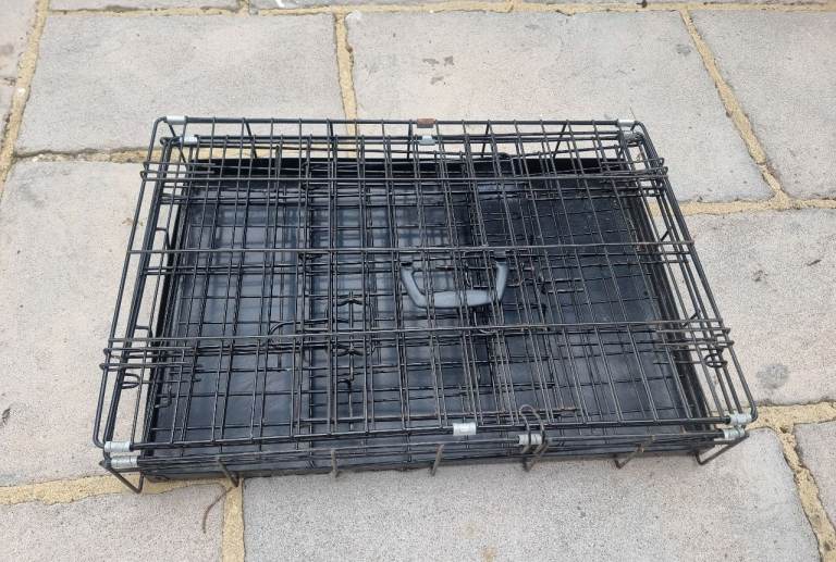 Black metal pet carrier or dog crate with plastic tray size small