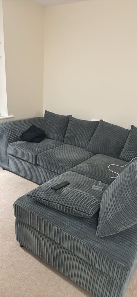 Grey L shaped scatter back cushioned sofa. 