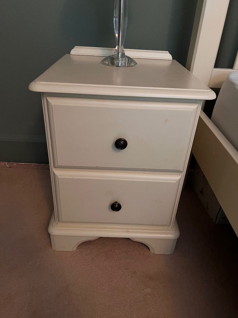 Two cream wooden bedside tables