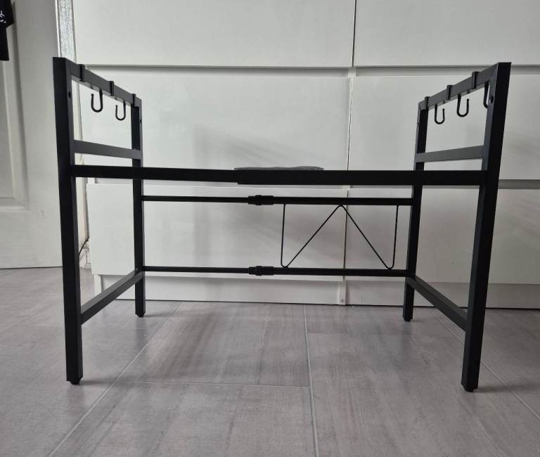 black metal expandable microwave oven rack with adjustable hooks for kitchen organization