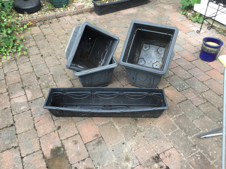 Five black square pots and matching trough