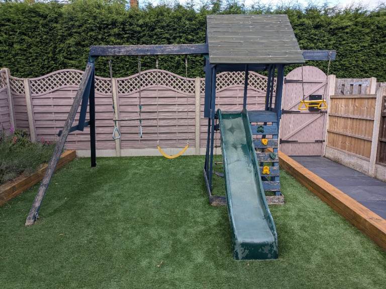 Wooden climbing frame with swings and slide