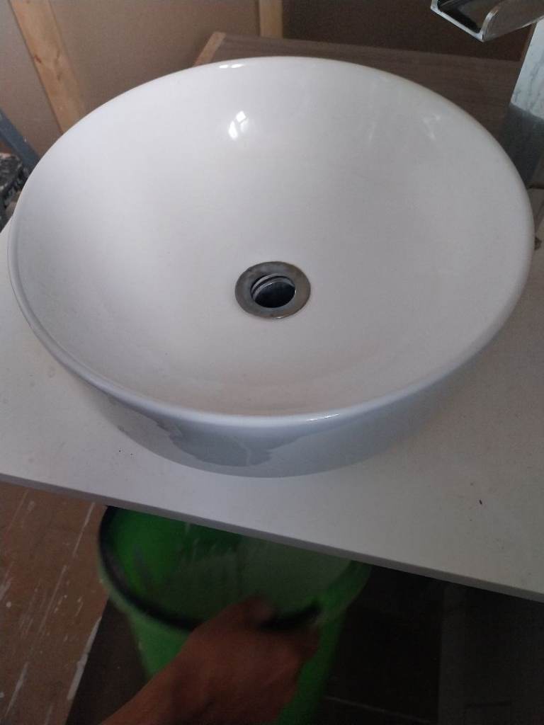 White countertop sink . Plus a tiolet .