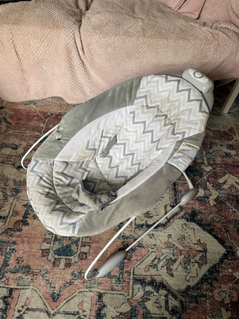 Grey baby bouncer with toys and sound