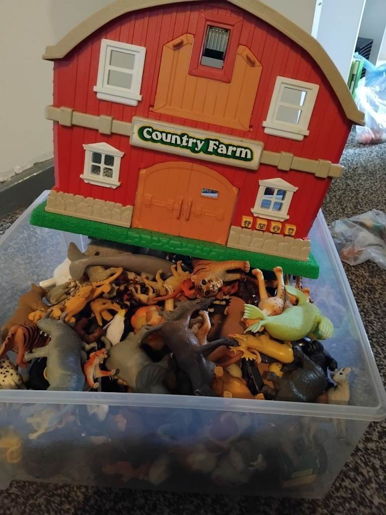 Box full of farm and zoo animals and toy farm 