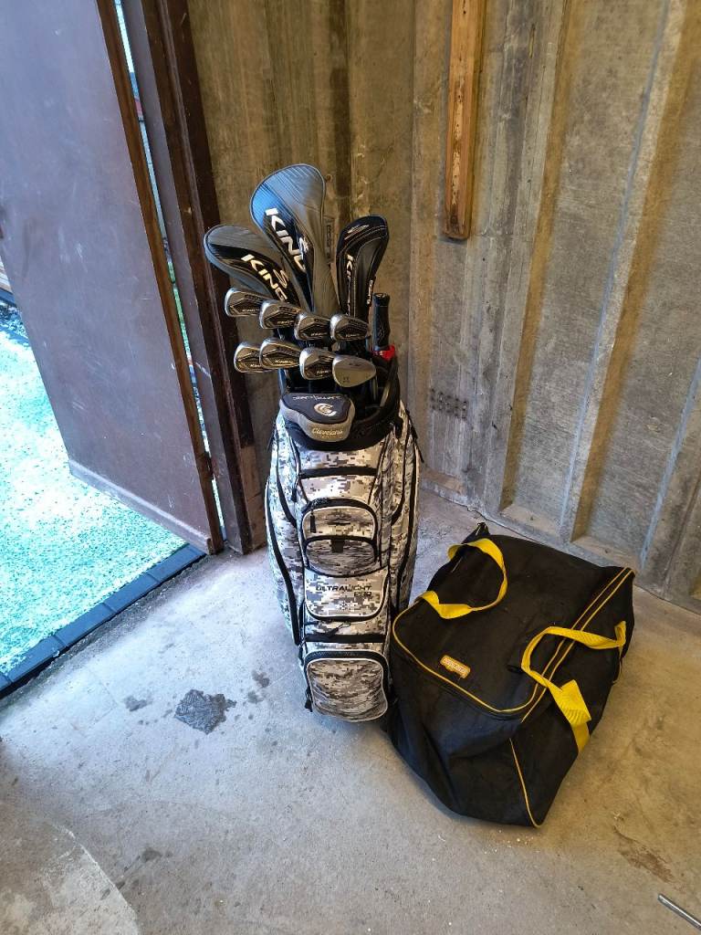 Set of cobra golf clubs, cart bag, rovic trolley, umbrella and assorted balls and tees.