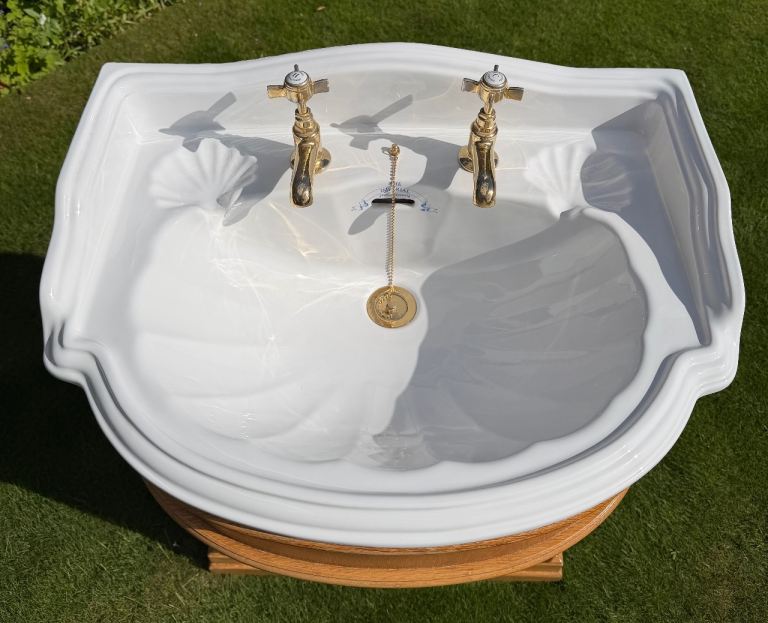 Sink and oak pedestal cupboard with gold taps