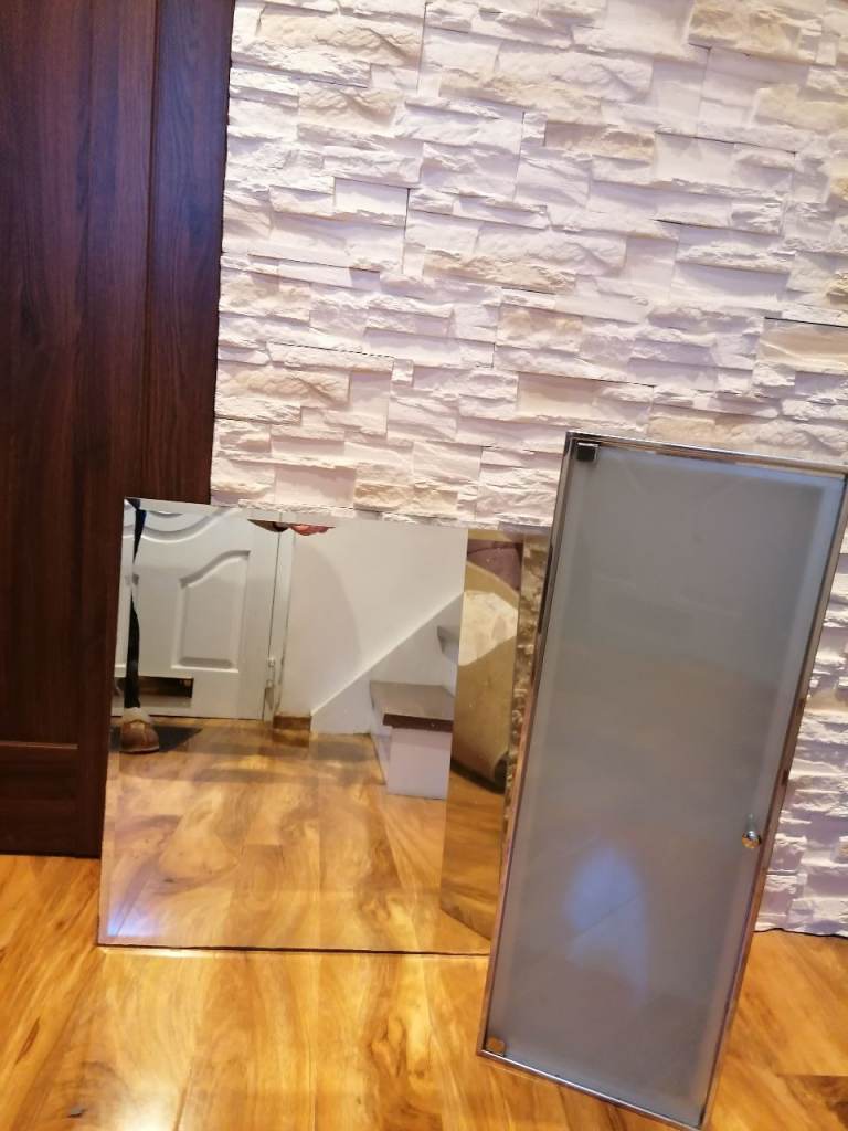 Frosted glass storage unit with 3 shelves and mirror.