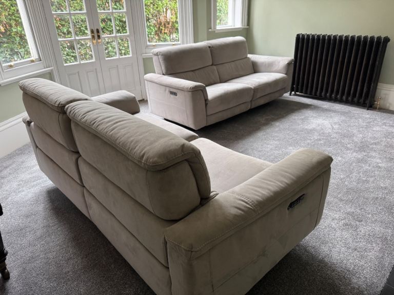 2 three seater electric recliner fabric sofas in a light grey/beige colour will split