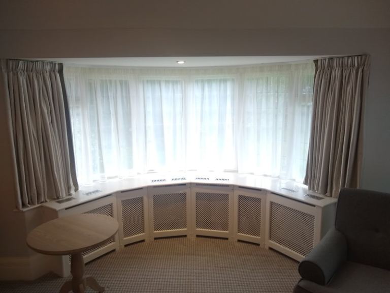Curtain and blinds fitter. Curtain tracks installation for bay windows