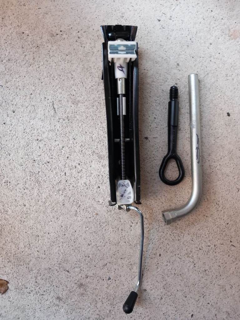 New car jack with wheel spanner and towing eye. 