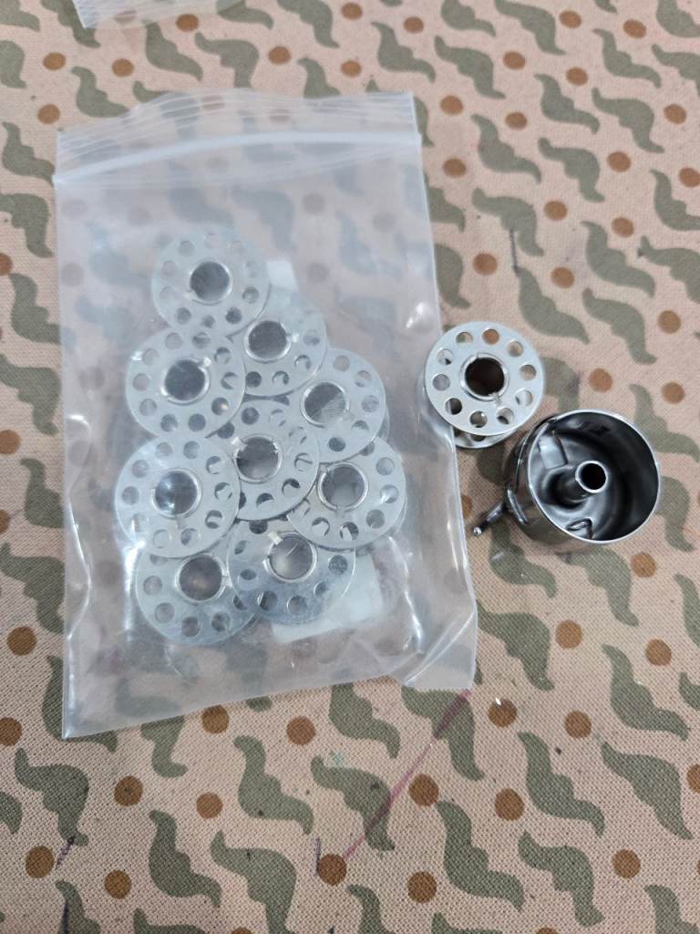 Sewing machine bobbins and bobbin cases