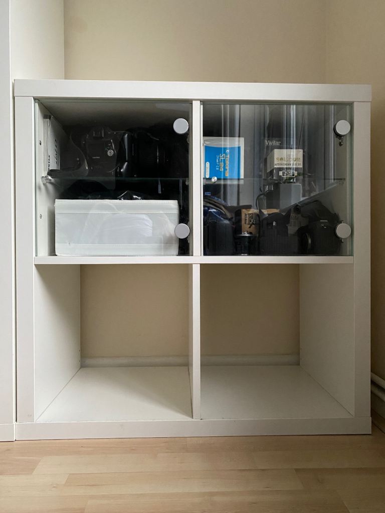 IKEA Kallax Storage Unit with glass doors and shelving inserts.