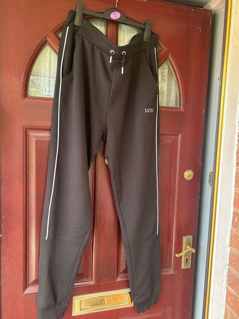 Man black tracksuit with white slim stripe bottoms 