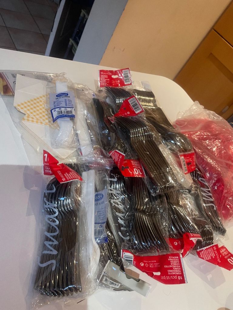 Large bundle of new plastic cutlery and party supplies.