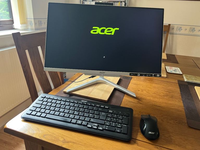 Compact Acer Aspire all-in-one computer with wireless keyboard and mouse, running Windows 11