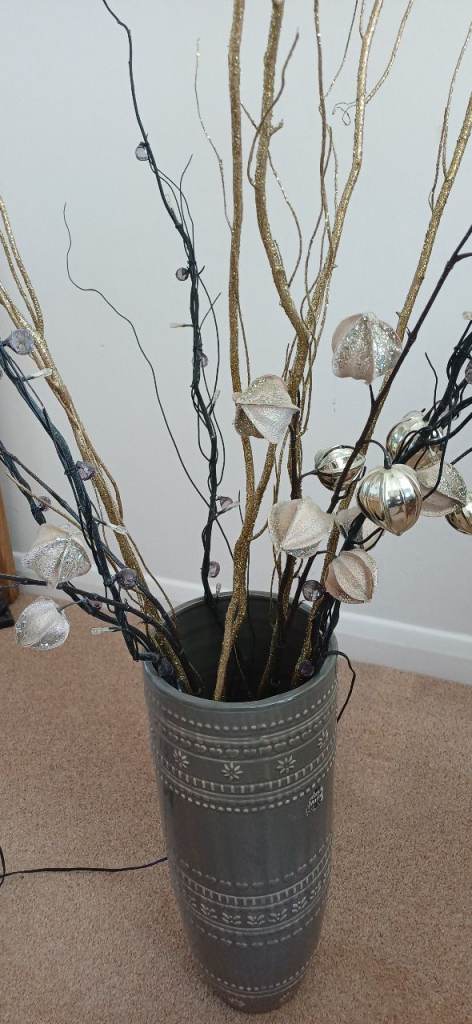 Grey ceramic vase with lights and other decorative twigs