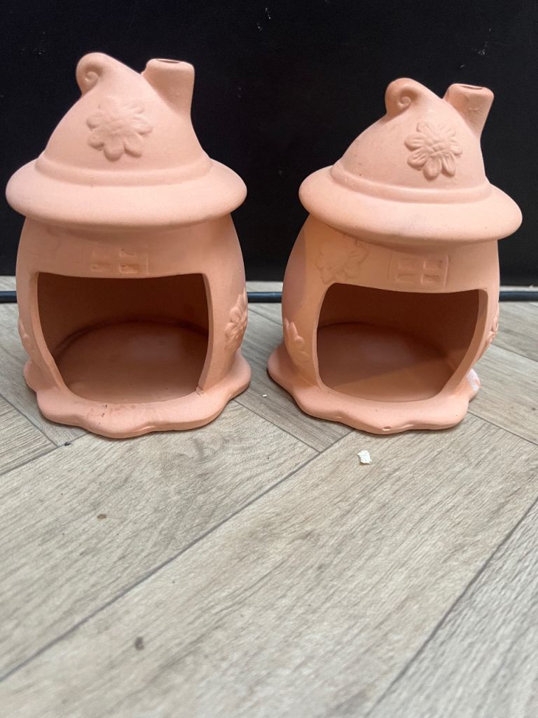 Two terracotta pet hideaways or shelters for small animals
