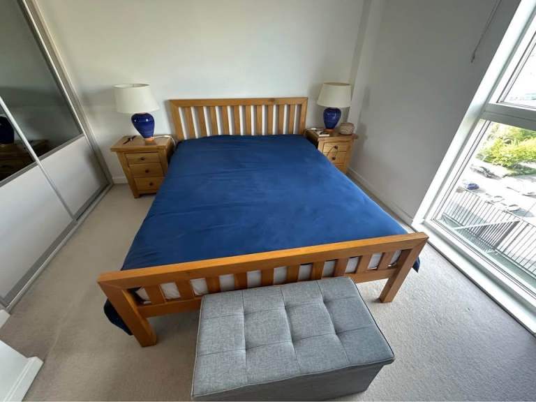 Solid oak bed with mattress.