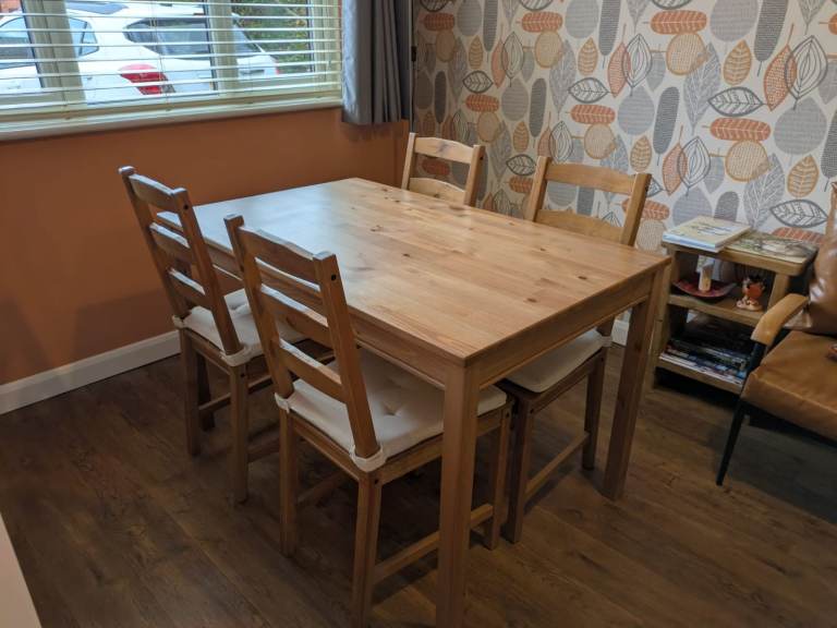 A lovely solid pine wooden dining table with four matching chairs