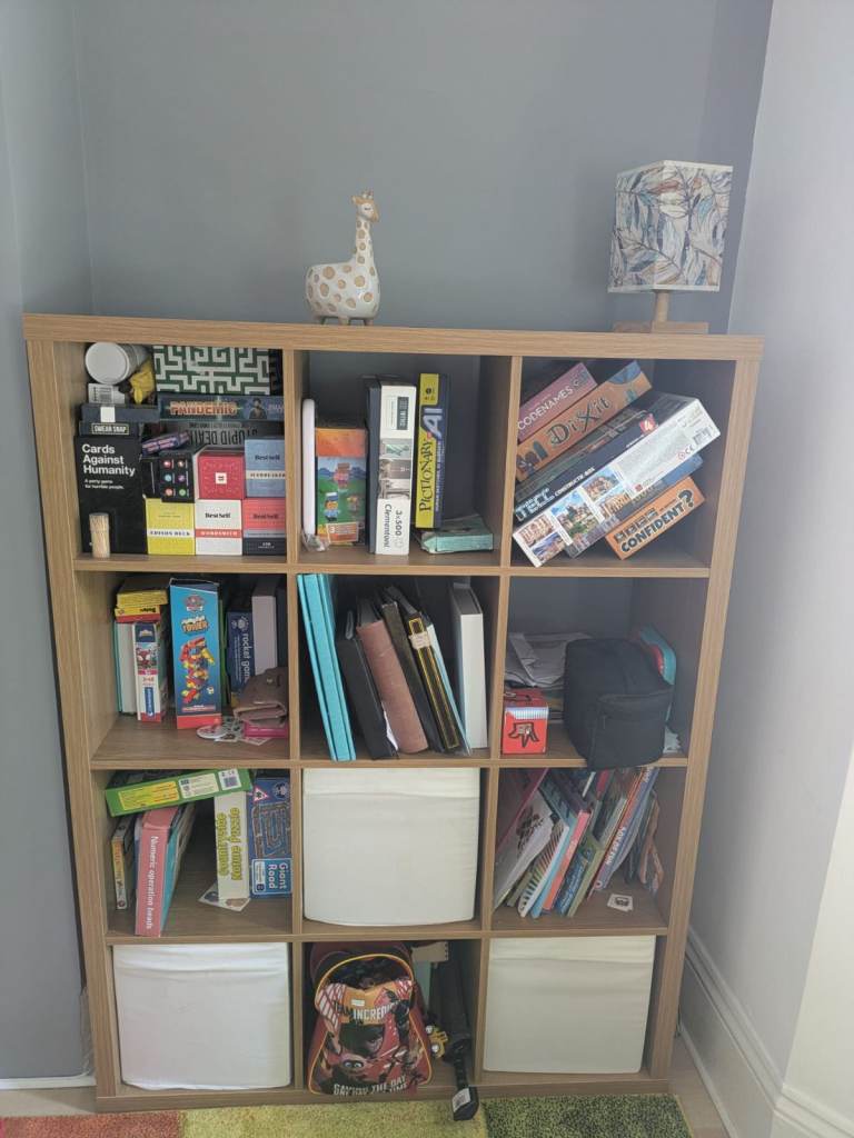 IKEA Kallax shelves with three white canvas boxes - brilliant for storing books, games, and toys.