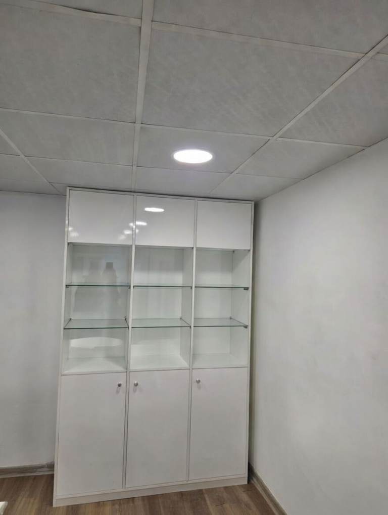 white high-gloss glass display cabinet with lower storage cupboards.