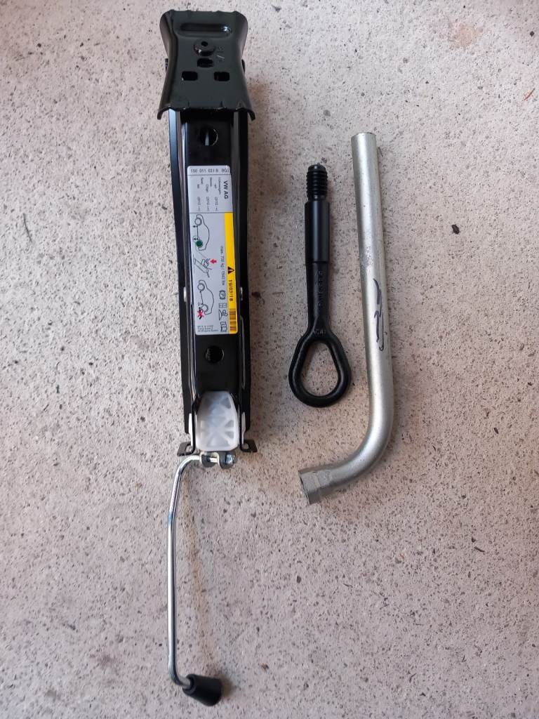 New car jack with wheel spanner and towing eye.