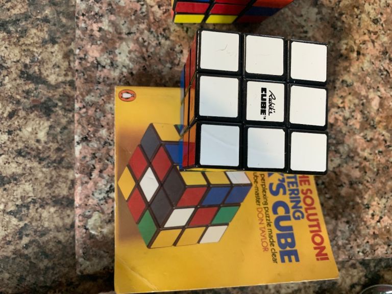 Two vintage Rubix cubes with cheat books