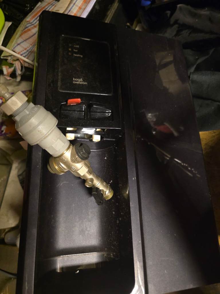 Unidentified Black Appliance with Plumbing Fittings