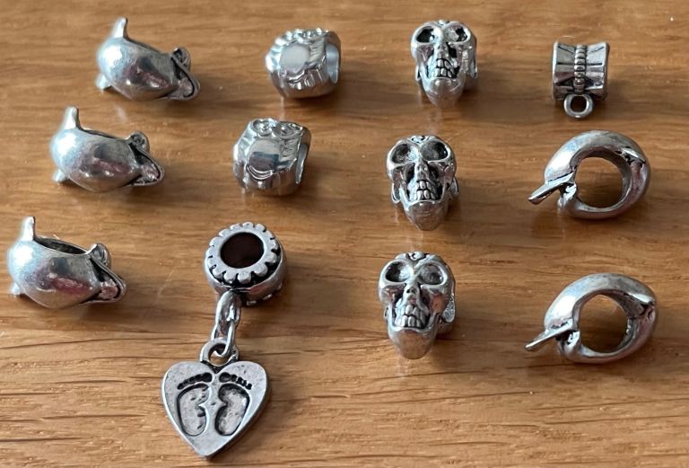 12 charms that fit Pandora & troll. Dolphins, feet with heart, skulls. £3 the lot. 
