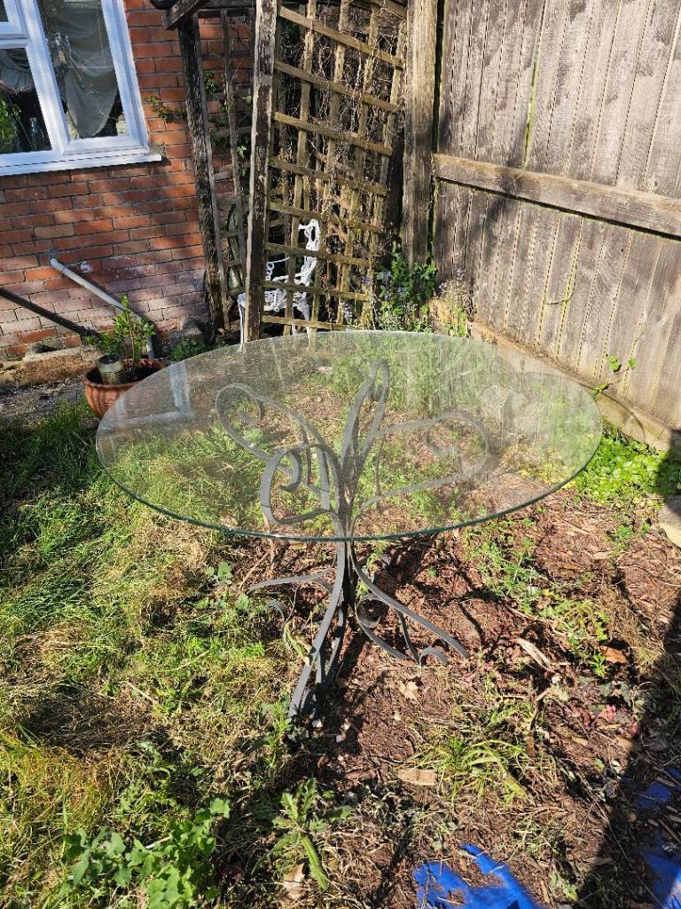 Glass garden table with 4 wrought iron chairs 