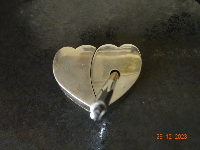 Metal heart shaped pen holder and pen.