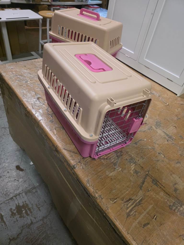 A new pink and beige plastic cat carrier the measurements are enclosed .