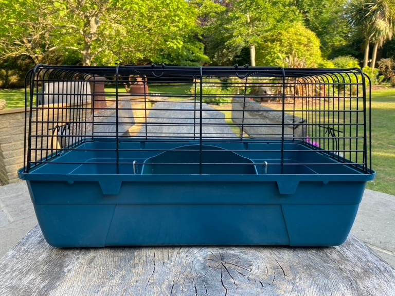 Small pet cage with dark blue base and black wire top