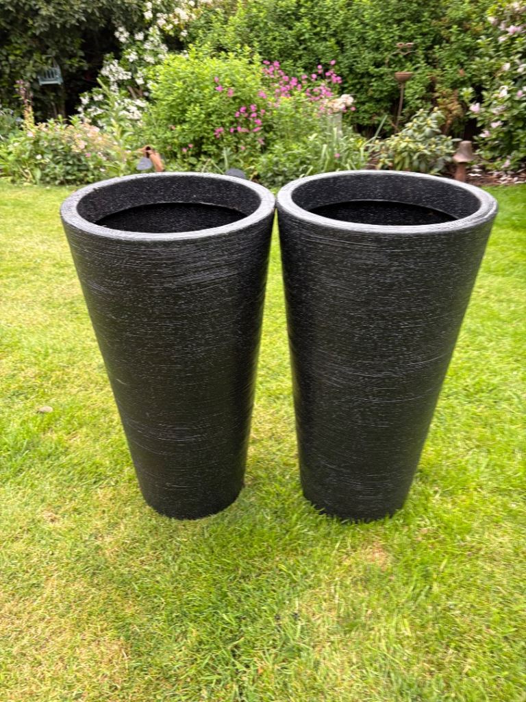 2 black tall plastic planters 