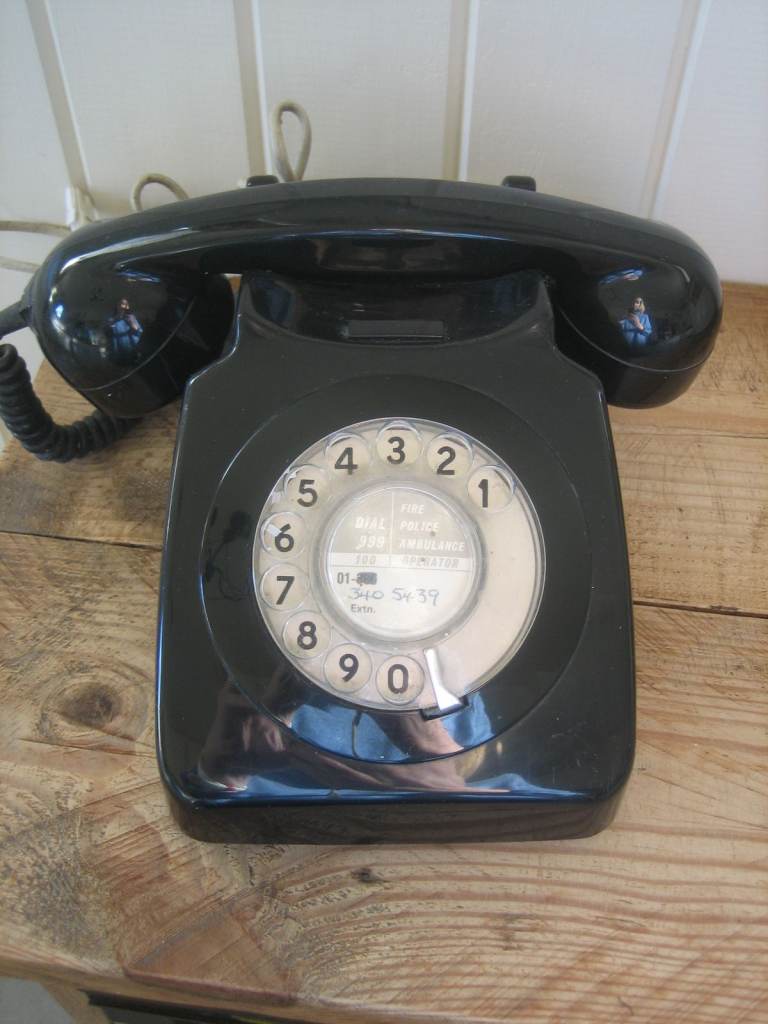Vintage black telephone with rotary dial.