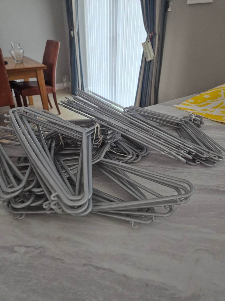 Bundle of Grey plastic clothes hangers.–